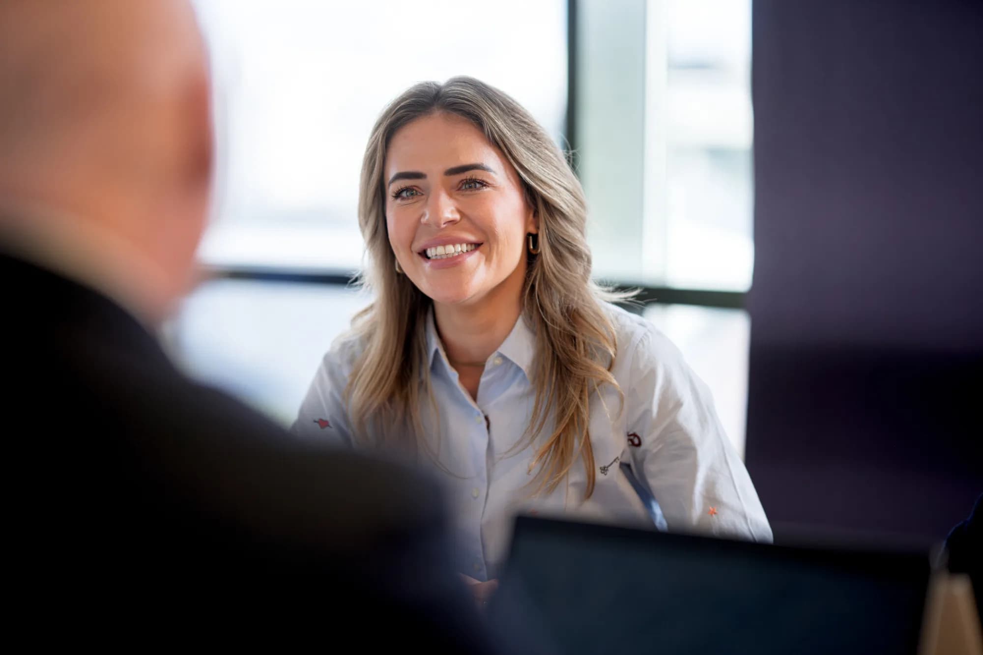 Vrouw glimlachend tijdens professioneel gesprek, recruitment marketing