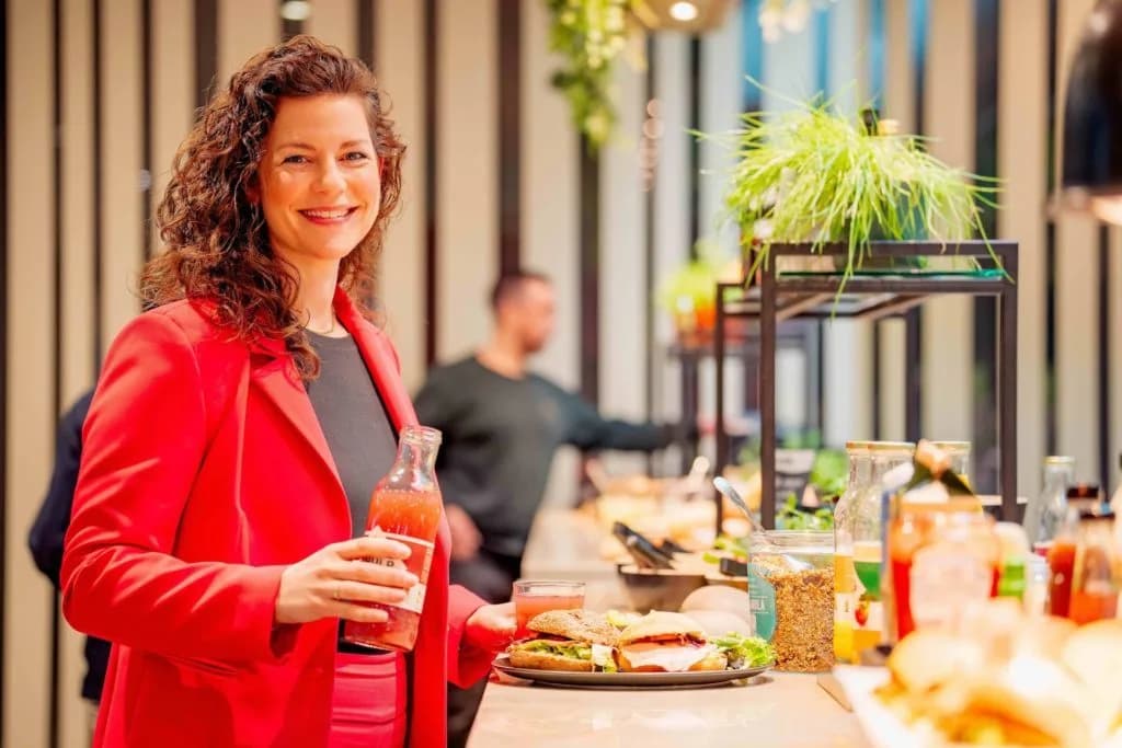 Een medewerker die lacht in de kantine, passend bij de sociale en inclusieve waarden van B Corp