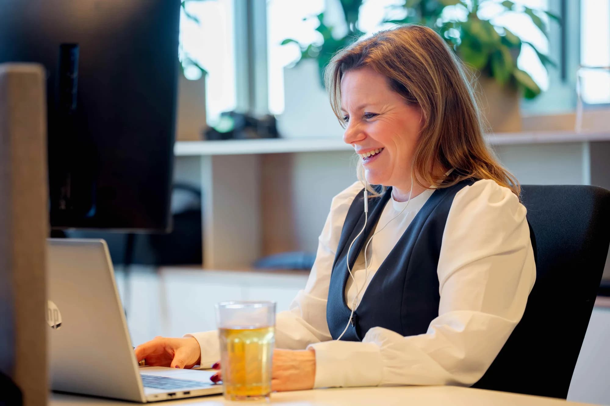 Vrouw achter laptop / hoe ai de toekomst van werk vormgeeft