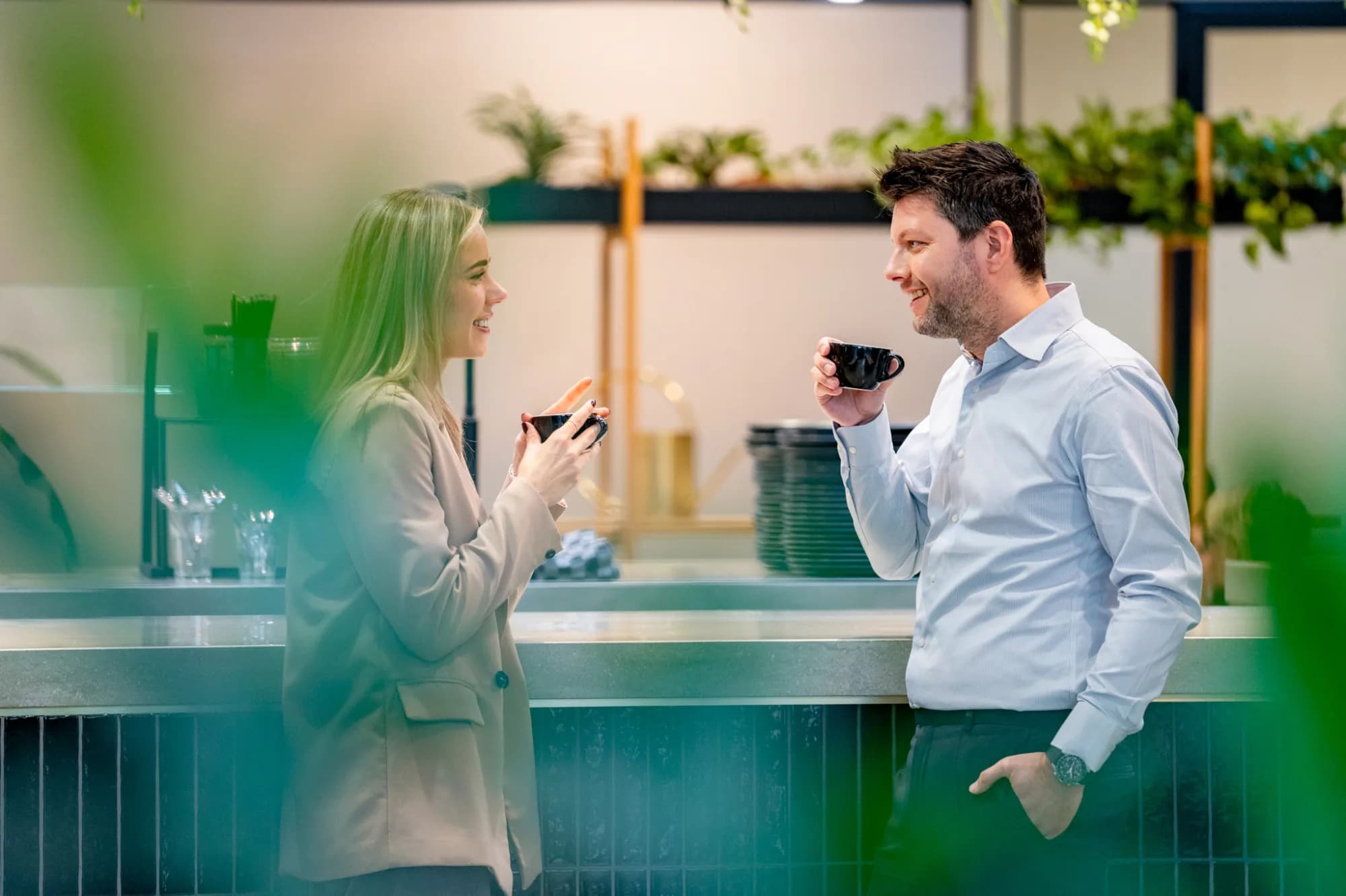 Twee personen in gesprek op kantoor.