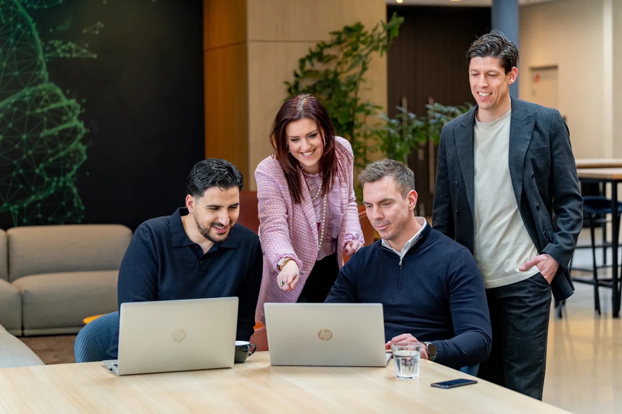 4 collega's kijken naar een laptop
