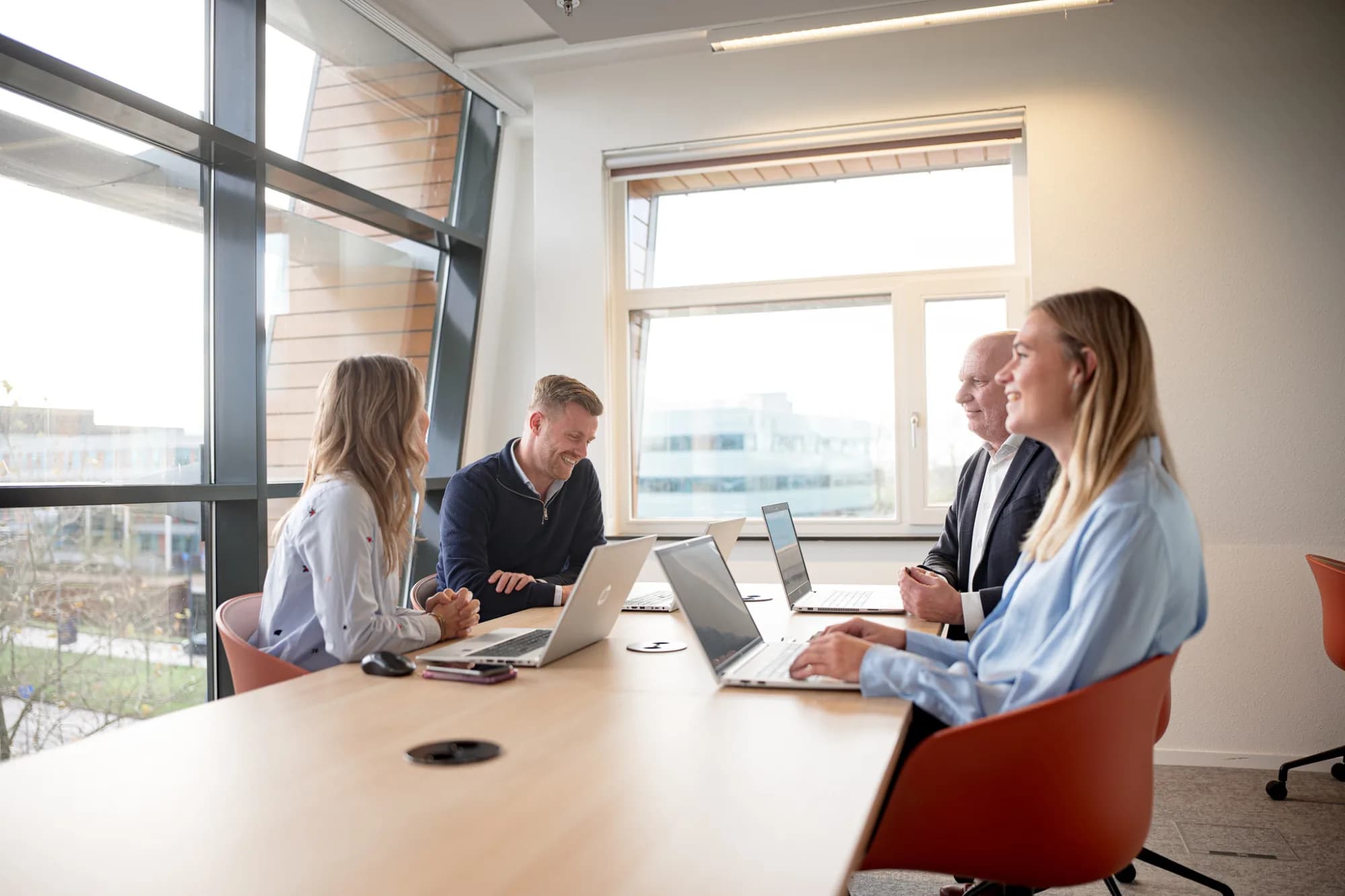 Vier personen in een meetingruimte bespreken datagedreven tariefbeheer en MSP-dienstverlening.