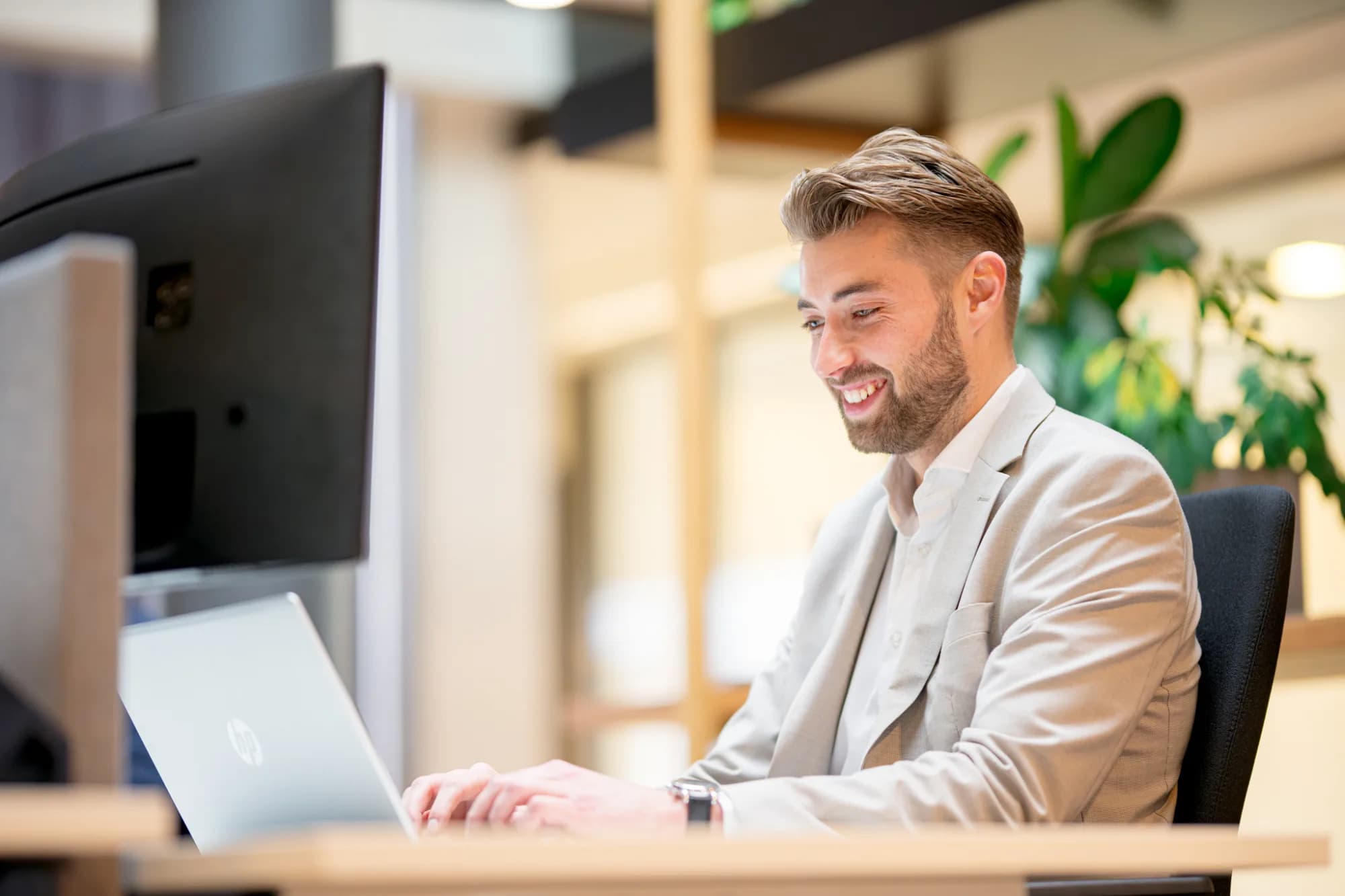 Persoon typt op een laptop aan een kantoortafel